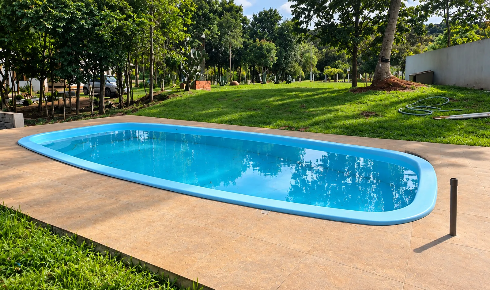 Piscina da unidade cercada por gramado e árvores
