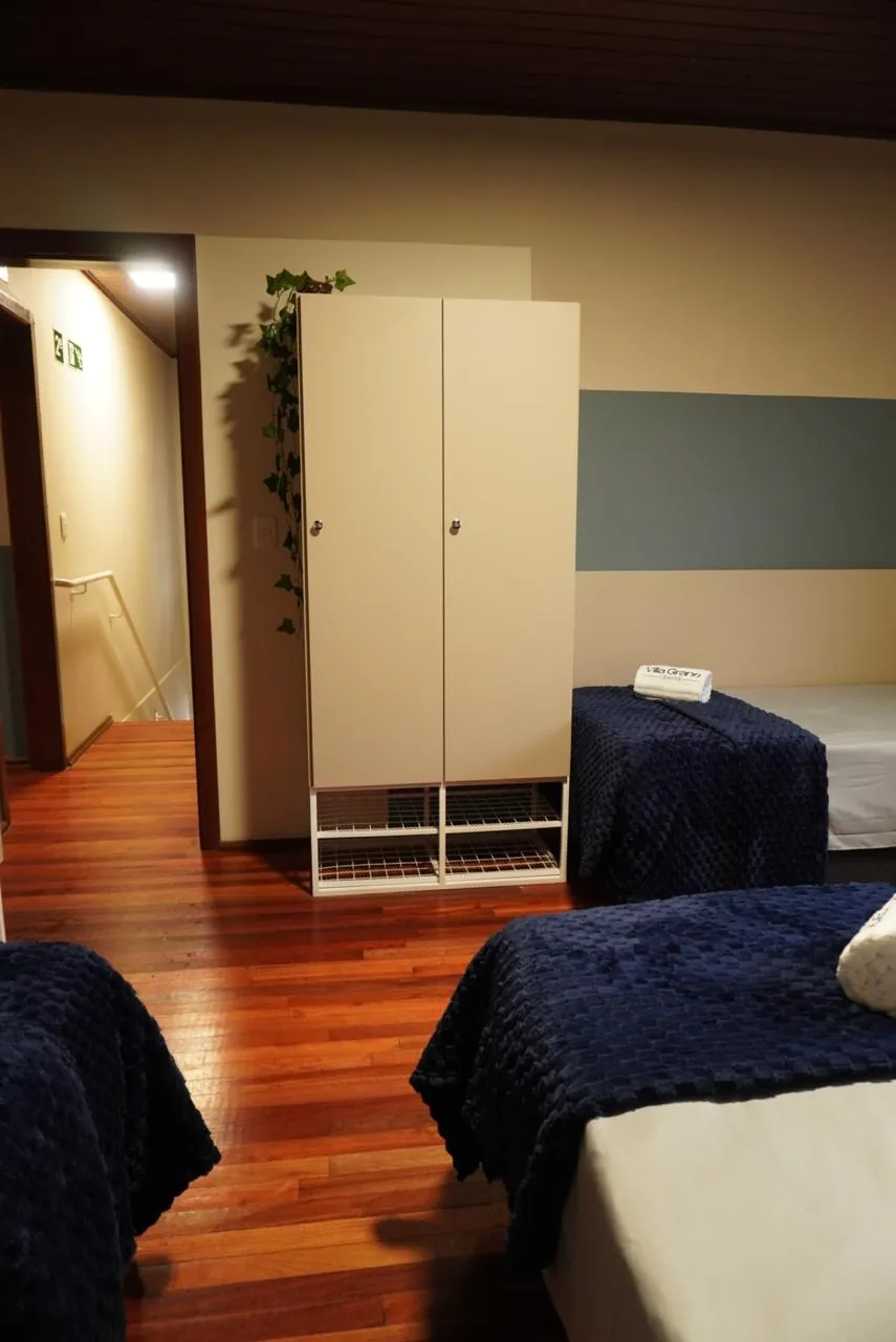 Corredor de quarto com armário branco e camas